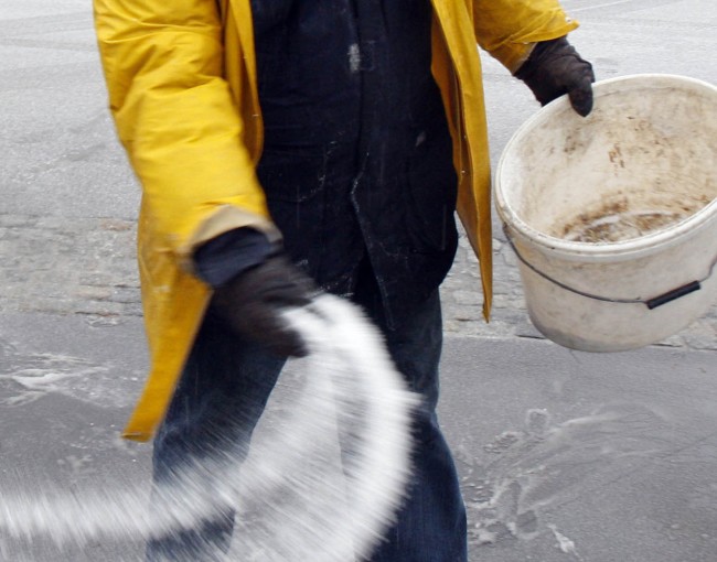 ** ALTERNATE CROP ** A worker spreads rock salt during an ice rain in Pamhagen, Austria, on Wednesday Jan. 14, 2009. (AP Photo/Ronald Zak)